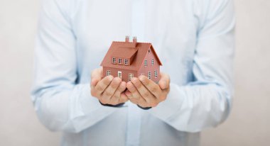 Ellerde küçük kahverengi oyuncak ev 