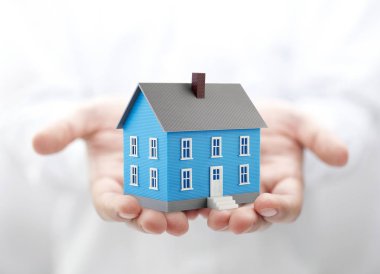 Ellerde küçük mavi oyuncak ev 