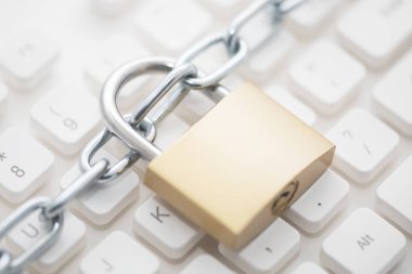 Security concept with metal padlock and chain on computer keyboard  clipart