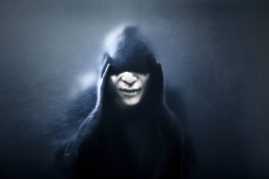 Tozlu bir camın arkasındaki hayalet figürü. Kapüşonlu pelerinli korkunç bir figür. 