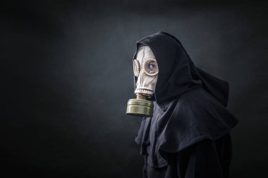 Man in a gas mask and hooded cloak. Environment pollution.  clipart