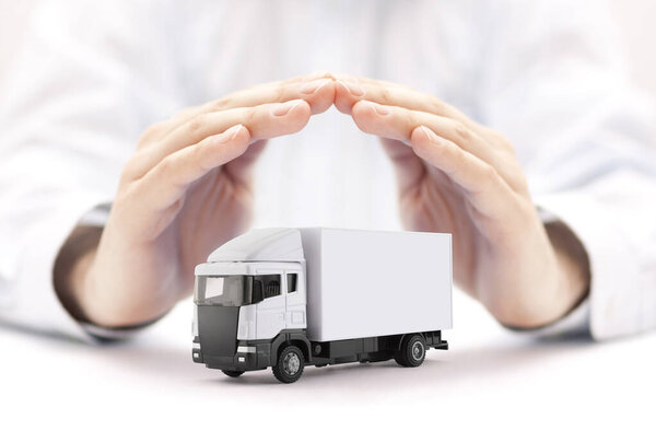White cargo delivery truck miniature protected by hands