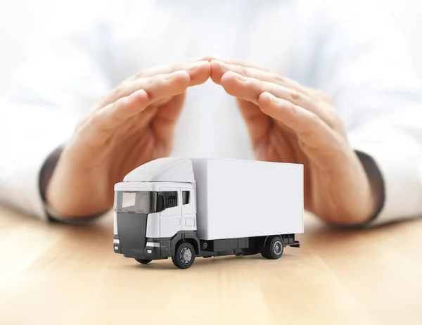 White cargo delivery truck miniature protected by hands