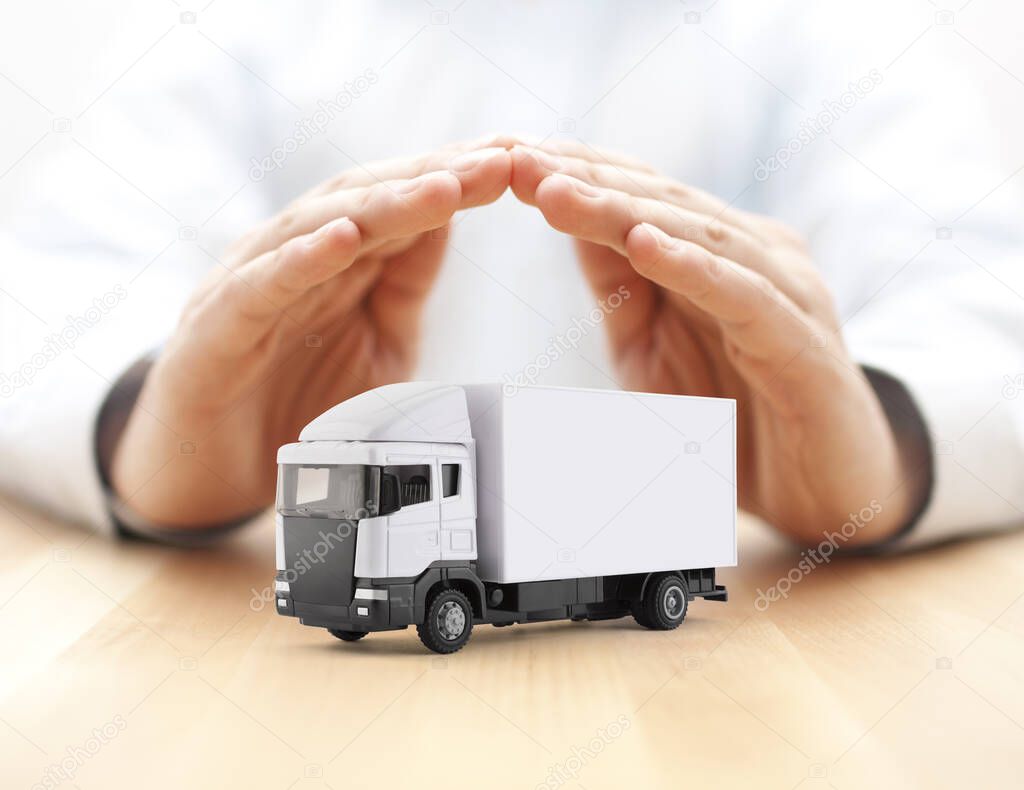 White cargo delivery truck miniature protected by hands