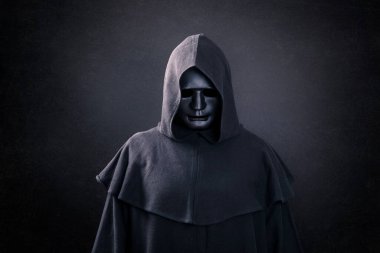 Scary figure with mask in hooded cloak in the dark clipart