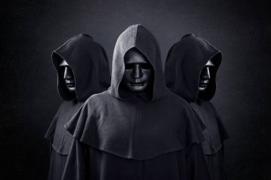 Group of three scary figures in hooded cloaks in the dark clipart