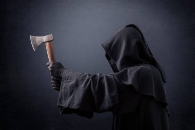 Karanlıkta baltayla kapüşonlu pelerinli korkunç bir figür.