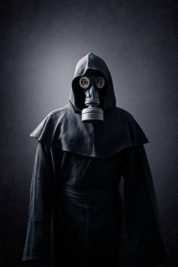 Gaz maskeli ve başlıklı bir adam. Çevre kirliliği.