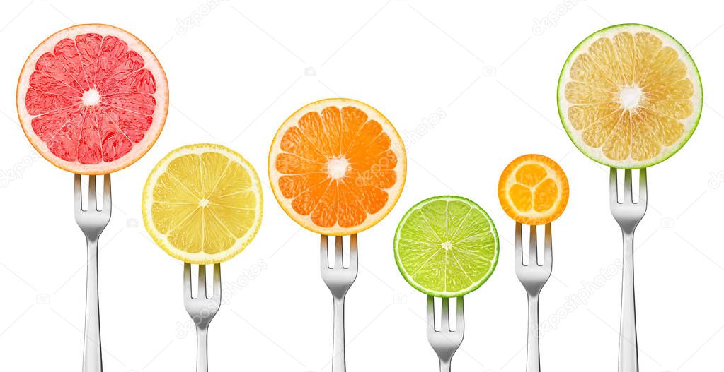 Isolated citrus slices. Pieces of grapefruits, lemon, orange, lime and kumquat on a dessert forks isolated on white background with clipping path