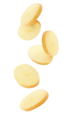 Havada izole patates parçaları var. Soyulmamış çiğ patates dilimleri beyaz arkaplandan aşağı düşüyor.