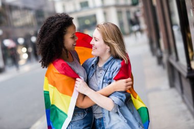 LGBT bayrağı taşıyan mutlu lezbiyen çift