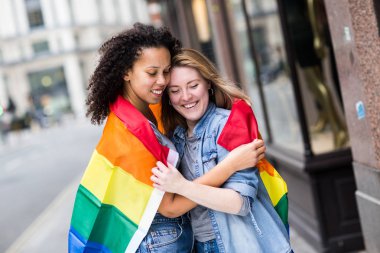 LGBT bayrağı taşıyan mutlu lezbiyen çift