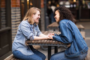 Lezbiyen çift oturmuş sohbet ediyorlar.