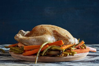 Ahşap kesme tahtası üzerinde sebze ile pişmiş tavuk