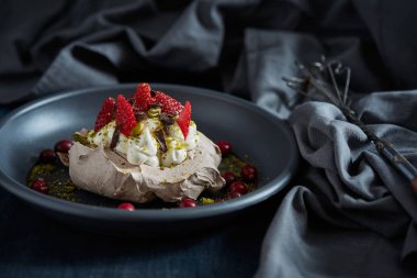 Siyah bir zemin üzerine krem şanti ile beze pasta