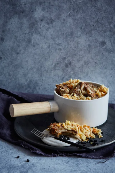 Rice dish with lamb ribs in a white pot