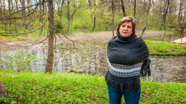 Orta yaşlı kadın fal bir panço Park'ta dinlenme