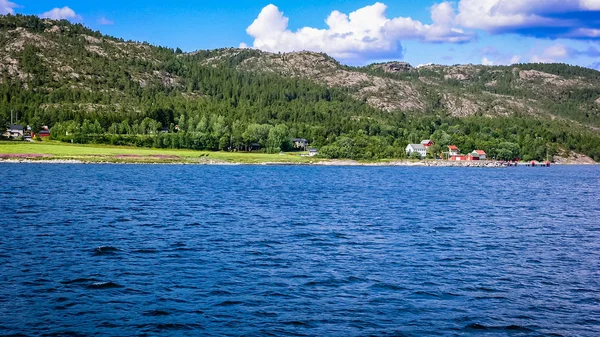 Vesnice na pobřeží norského fjordu s molo pro lodě — Stock fotografie