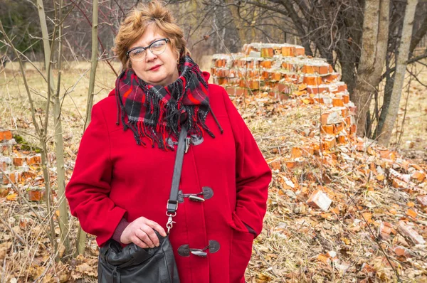 Žena středního věku s brýlemi a červené sako — Stock fotografie