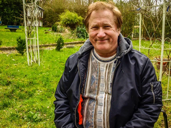 Un uomo anziano in giacca che riposa nel parco — Foto Stock