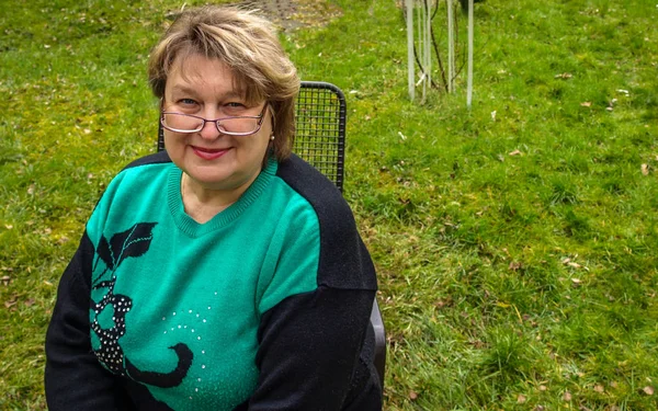 Женщина средних лет в очках, отдыхающая в парке — стоковое фото
