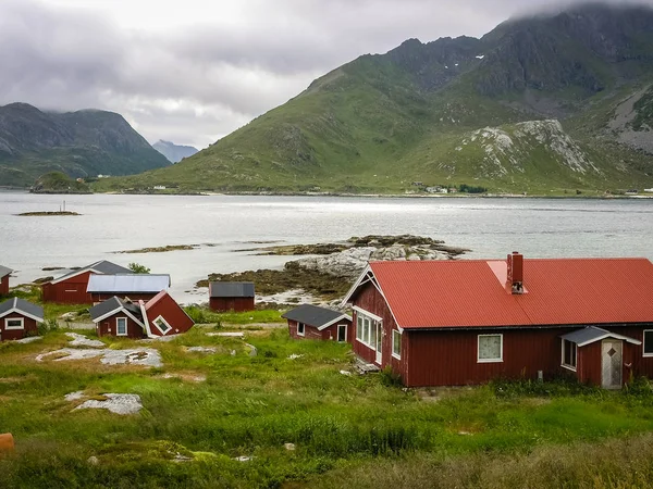 Vesnice na skalnatém břehu fjordu v Norsku s Traditi — Stock fotografie