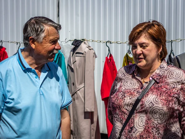 Ancianos hombre y mujer se comunican en el mercado — Foto de Stock