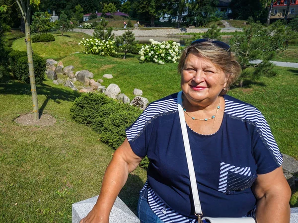 Velha mulher descansando no parque da cidade — Fotografia de Stock