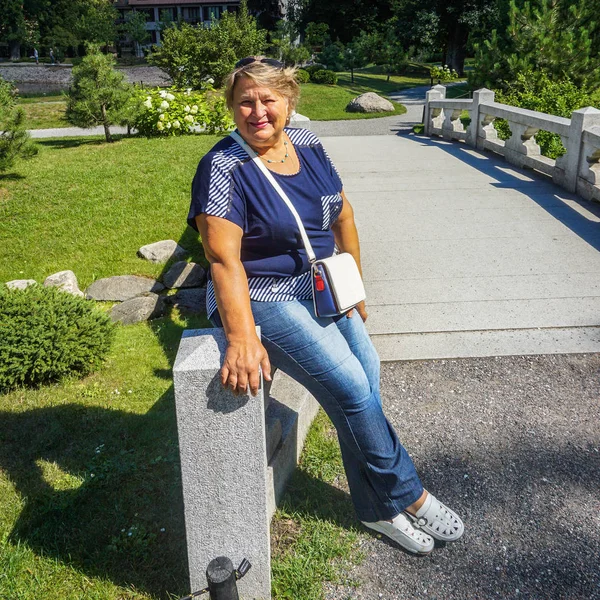 Γριά γυναίκα που αναπαύεται στο πάρκο της πόλης — Φωτογραφία Αρχείου