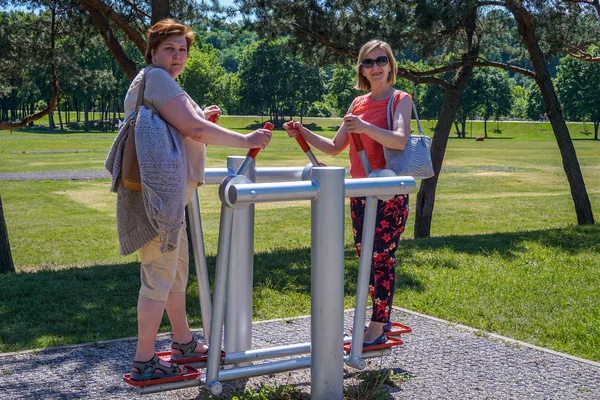 두 성숙한 여자는 공원에서 시뮬레이터에 종사 — 스톡 사진