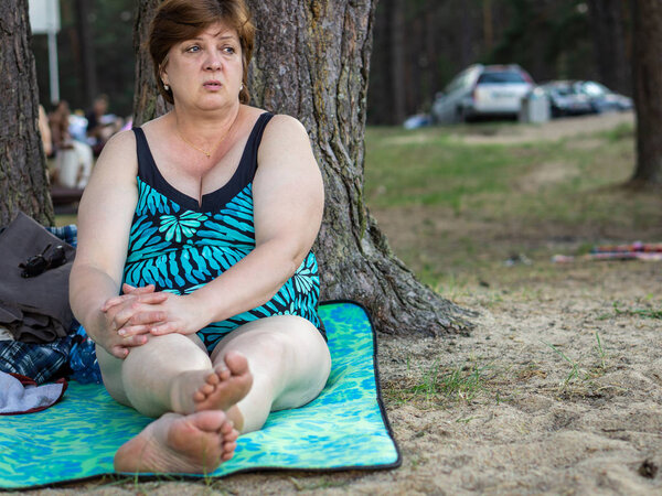 Зрелая женщина отдыхает на пляже у озера
. 