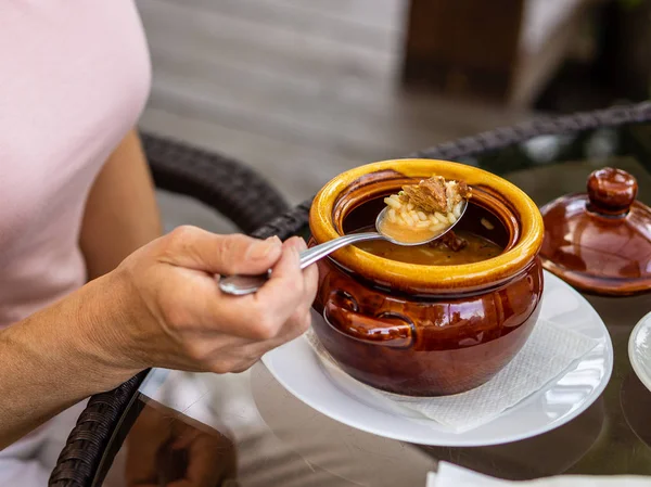 Rijpe vrouw die soep in Café eet Stockfoto