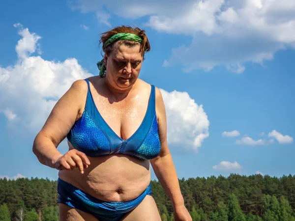 Femme mûre en maillot de bain sort de l'eau — Photo