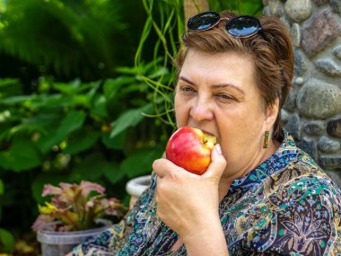 Olgun kadın kırmızı elma yeme 