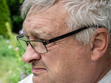 Önünde bakan gözlükile kuluçka ve kızgın yaşlı dedesi