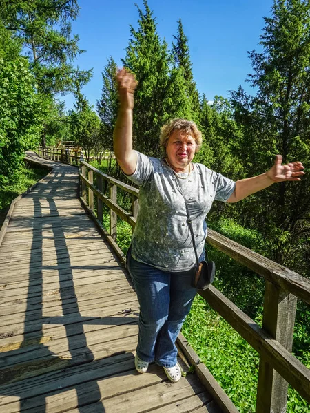 Mature woman resting in a juniper Park by the river — Stock Photo, Image