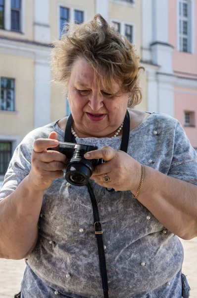 En gammal kvinna med en kamera som vilar i stadsparken — Stockfoto