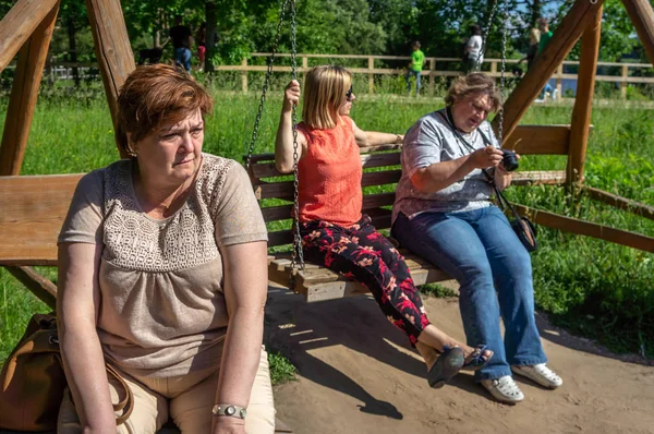 Las mujeres maduras turistas relajarse en el parque de enebro junto al río —  Fotos de Stock