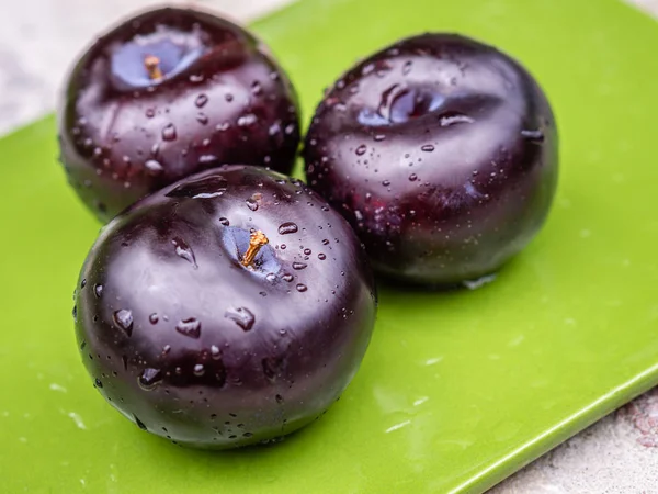 Drei dunkelviolette Pflaumenfrüchte aus nächster Nähe — Stockfoto