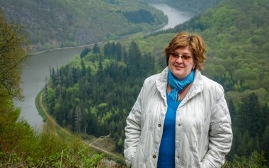 Park'ta dinlenmiş beyaz ceket li ve gözlüklü olgun kadın 