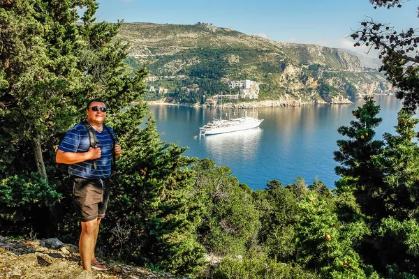 Un jeune homme aux lunettes de soleil reposant au bord de la mer — Photo