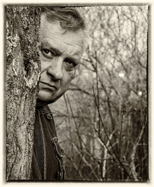 Brooding ongeschoren oude grootvader kijkt in de voorkant van hem — Stockfoto