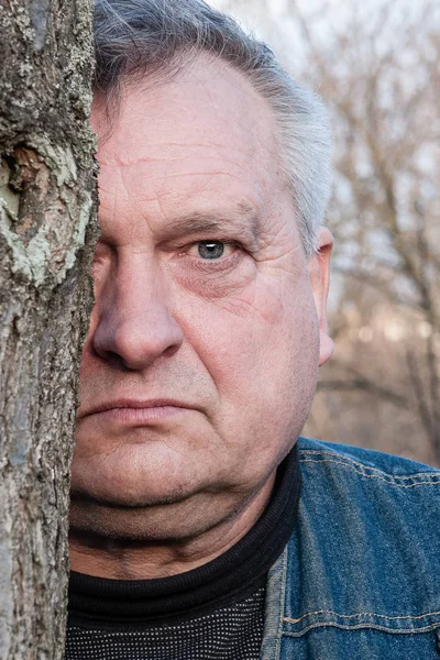 Brooding ongeschoren oude grootvader kijkt in de voorkant van hem — Stockfoto