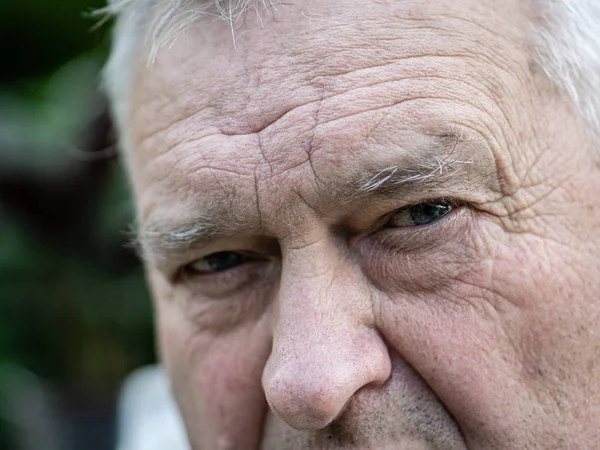 Brooding ongeschoren oude grootvader kijkt in de voorkant van hem — Stockfoto