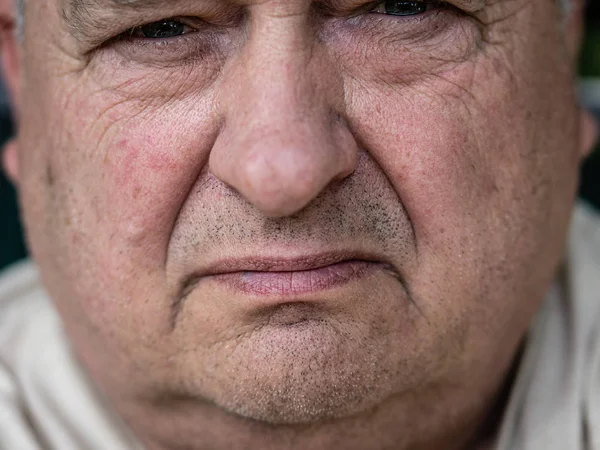 Brooding ongeschoren oude grootvader kijkt in de voorkant van hem — Stockfoto