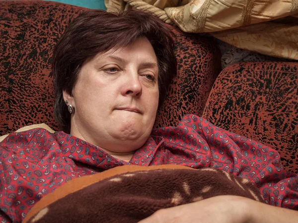 Medelålders kvinna vilar på soffan hemma — Stockfoto