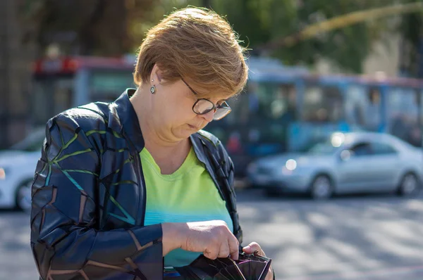 Mogen kvinna med glasögon går gatorna i staden — Stockfoto
