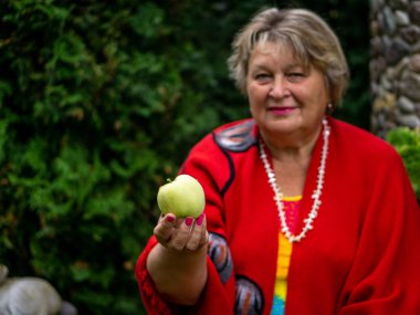 Elinde bir Elma ile kırmızı olgun kadın 