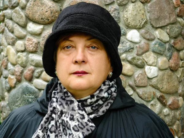 Pensive Mature woman in a black hat resting — Stock Photo, Image