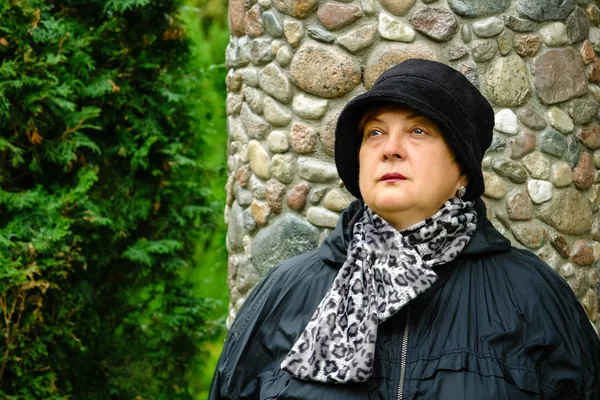 Pensive Mature woman in a black hat resting — Stock Photo, Image